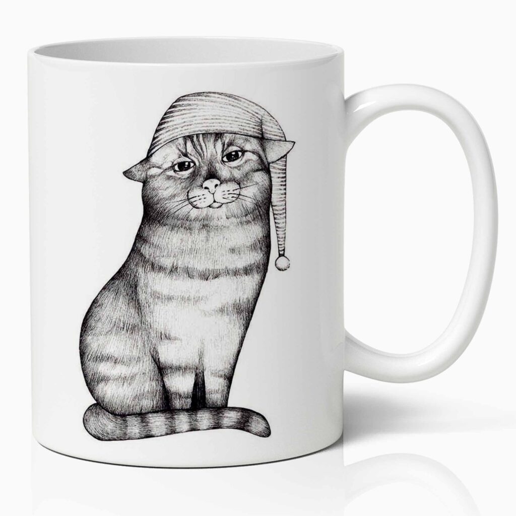 Keramische witte mok met een zwart/wit tekening van een poes met een slaapmuts. De mok heeft een inhoud van 330 ml en kan in de vaatwasser en in de magnetron.