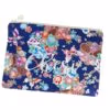 Grote blauwe stoffen toilettas met bloemenmotief en geborduurde tekst 'Cheri' op een witte achtergrond.