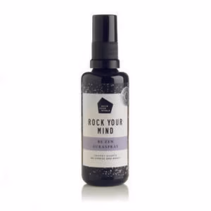 Be Zen Spray van Rock Your World. Een glazen flesje met een wit met lila kleurig label waar Be en spray op staat.