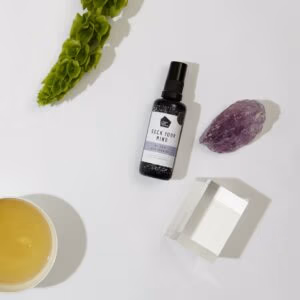 Be Zen Spray van Rock Your World. Een glazen flesje met een wit met lila kleurig label waar Be en spray op staat.