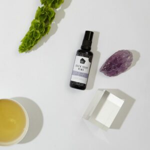 Be Zen Spray van Rock Your World. Een glazen flesje met een wit met lila kleurig label waar Be en spray op staat.