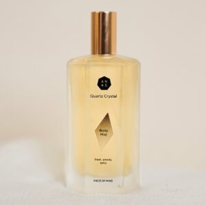 ANAS body mist in een glazen fles met goudkleurige dop.