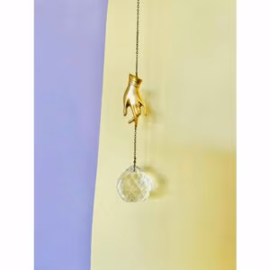 Suncatcher met een decoratieve goudenhhand op de achtergrond de kleuren geel en lila.