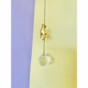 Suncatcher met een decoratieve goudenhhand op de achtergrond de kleuren geel en lila.