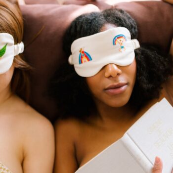 Twee mensen hebben een wit slaapmasker op met de regenboogsymbolen met twee menselijke illustraties.