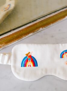 Wit slaapmasker van biologisch katoen satijn met borduursels twee regenboog symbolen met een vrouw en een man.