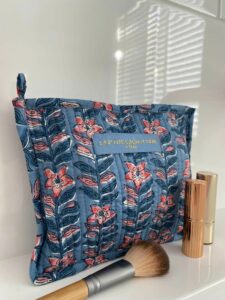 Make-up tas Jodhpur blokprint in de kleuren blauw, roze, crème wit van het merk La p'tite Cachottière. De toilettas staat op een wastafel er staan wat make-up artikelen naast.