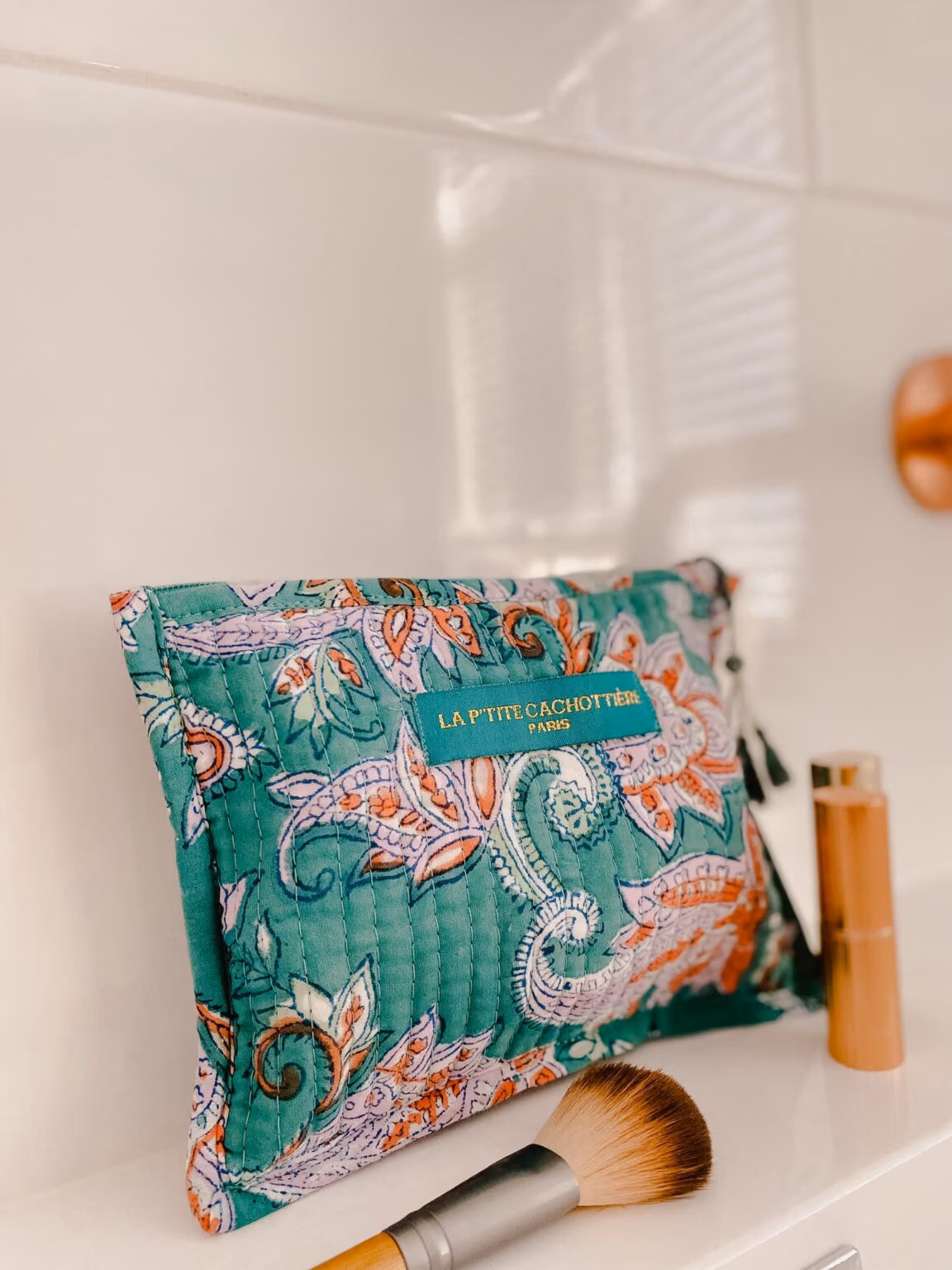 Make-up tas zeegroen blokprint in de kleuren zeegroen, roze, wit van het merk La p'tite Cachottière. De toilettas staat op een wastafel er staan wat make-up artikelen naast.