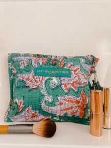 Make-up tas zeegroen blokprint in de kleuren zeegroen, roze, wit van het merk La p'tite Cachottière. De toilettas staat op een wastafel er staan wat make-up artikelen naast.