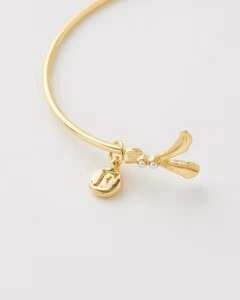 Deze armband, versierd met een roodborstje en maretak, symboliseert geluk en een nieuw begin. Gemaakt van duurzaam messing, met handbeschilderd emaille en 14k goud vergulde details, past hij perfect om elke pols.
