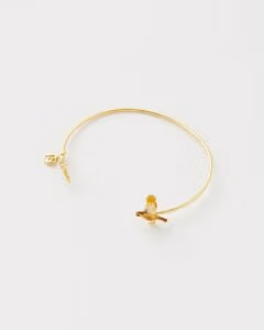 Deze armband, versierd met een roodborstje en maretak, symboliseert geluk en een nieuw begin. Gemaakt van duurzaam messing, met handbeschilderd emaille en 14k goud vergulde details, past hij perfect om elke pols.