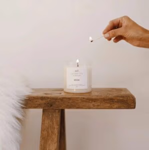 Winter handgemaakte natuurlijke geurkaars met inaasappel, verveine, patchouli, amber en vanille. In glazen pot de kaars is wit.