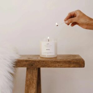 Winter handgemaakte natuurlijke geurkaars met inaasappel, verveine, patchouli, amber en vanille. In glazen pot de kaars is wit.