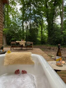 Buitenbad met vrouw erin tijdens het self-care weekend in het bos in Joppe.