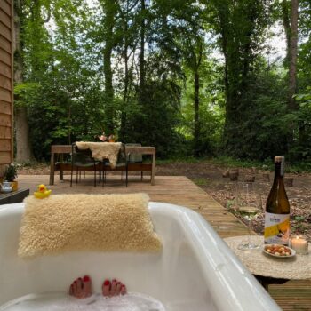 Buitenbad met vrouw erin tijdens het self-care weekend in het bos in Joppe.