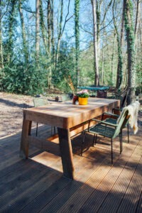 Houtentafel die in de zon staat in het boshuis in Joppe.