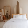 Coco & Cici Bamboe Beddengoed Wit, opgemaakt op een bed, voor een luxe en comfortabele slaapervaring met duurzame, hypoallergene en ademende eigenschappen.