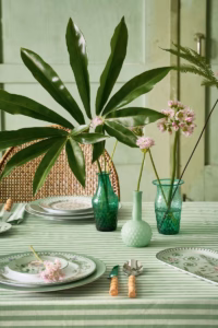 Drie blauwgroene Pip Studio vaasjes op een elegant gedekte tafel met bloemen.