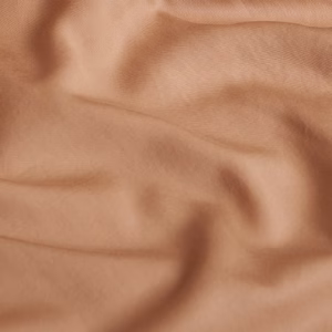 Close-up van de Coco & Cici Tencel beddengoed perzik, die de zachte textuur en matte afwerking laat zien.