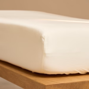 Coco & Cici Satijn Hoeslaken Crème om matras, gemaakt van ademend TENCEL™ Lyocell voor luxe slaapcomfort.