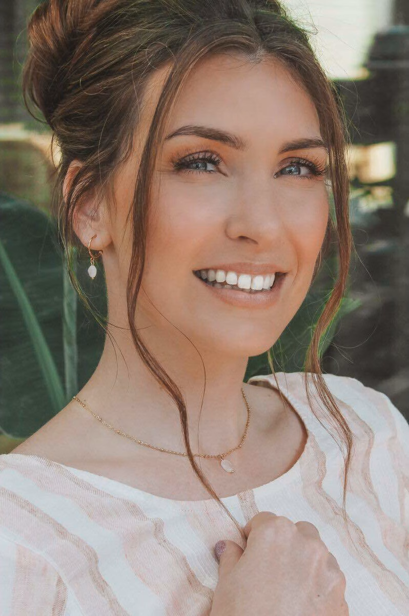Vrouw met goudkleurige maansteen ketting van Saint Clairmont – model in natuurlijke setting