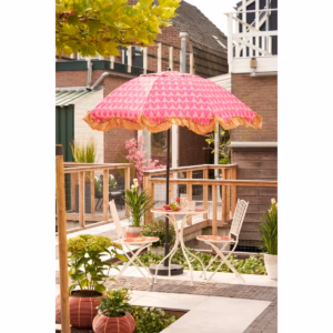 Roze parasol met hartjes in de tuin, gestyled met buitenmeubilair en zomerse accessoires.