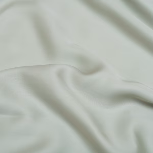 Close-up van de TENCEL™ Lyocell stof van het Coco & Cici Satijn Hoeslaken Grijs Groen, zijdezacht en ademend.