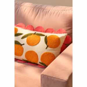 Sierkussen met sinaasappel van Mica Decorations, gestyled op een roze bank vrolijk en kleurrijk ontwerp voor je interieur.