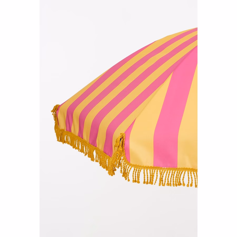 Zijaanzicht van geel-roze parasol met franjes – gestreept doek en sierlijke rand zichtbaar.